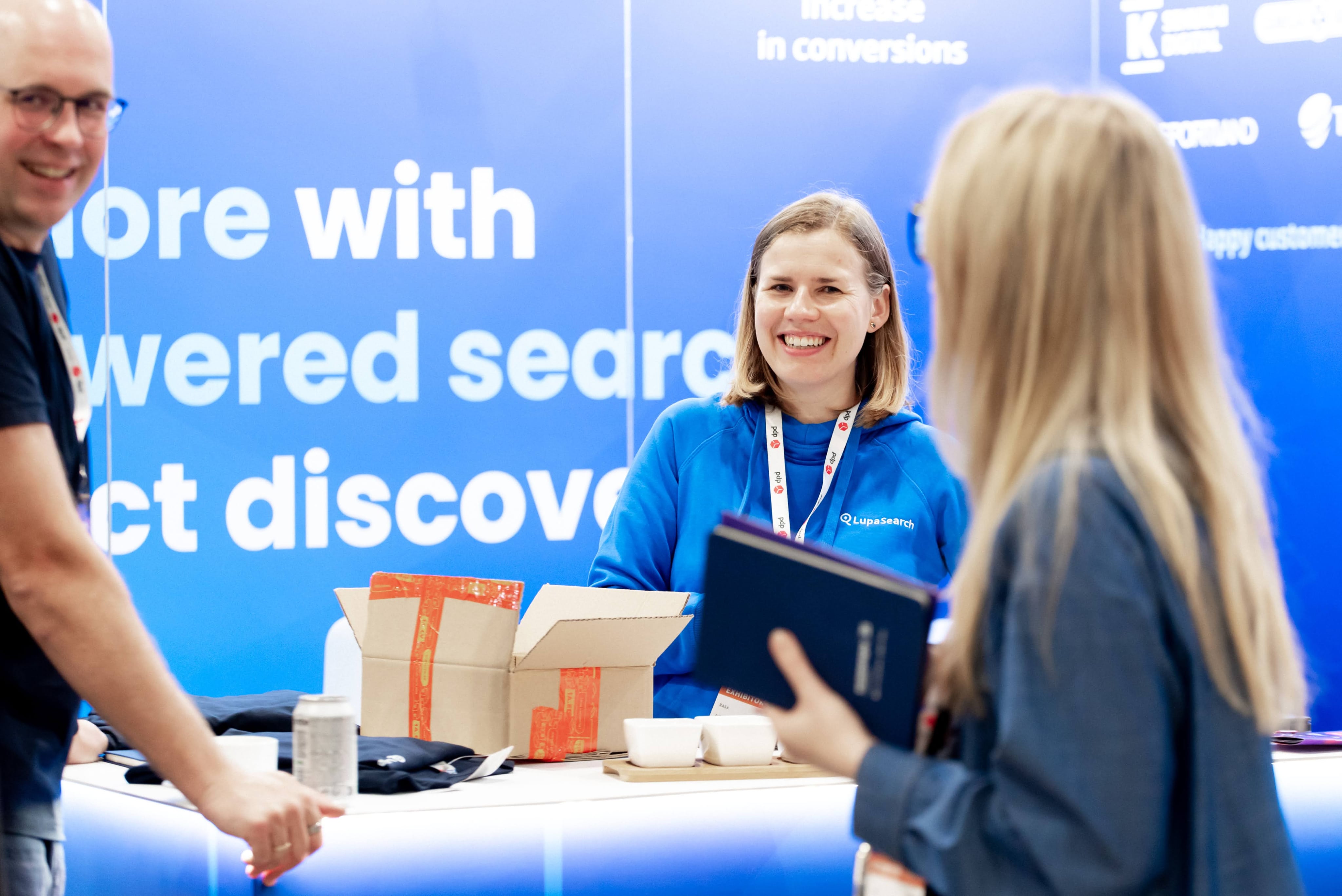 LupaSearch team member greeting visitors at an ecommerce conference booth